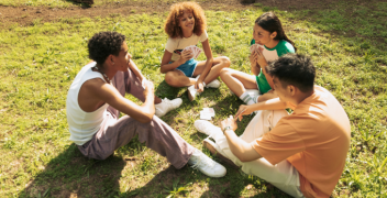 teens sitting in a circle on grass