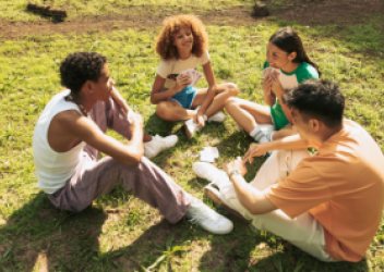 teens sitting in a circle on grass